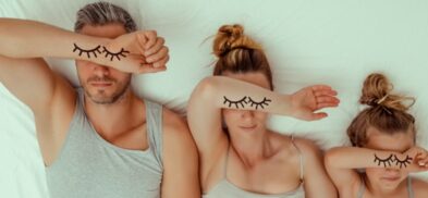 family in bed with eye lashes on forearm and over their eyes for Sleep awareness week